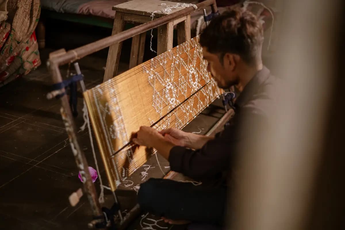 A vibrant modern Patola gown is displayed elegantly, showcasing the blend of traditional double ikat weaving with contemporary Western fashion design.